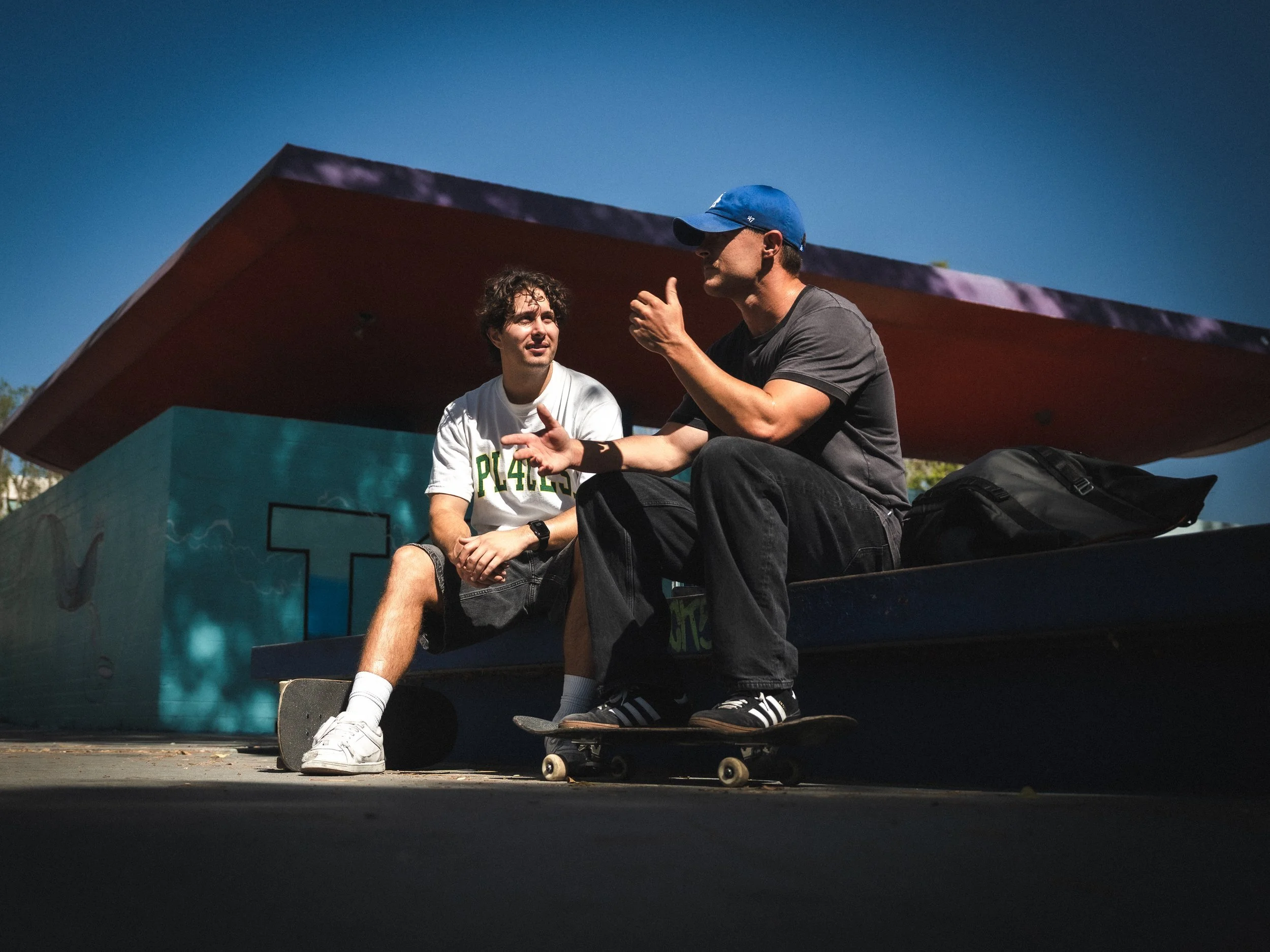 Brandon Loufas and Isaiah Rojers under the red roof at the West LA Courthouse skatepark, Los Angeles skate photography by Osy Ikhile