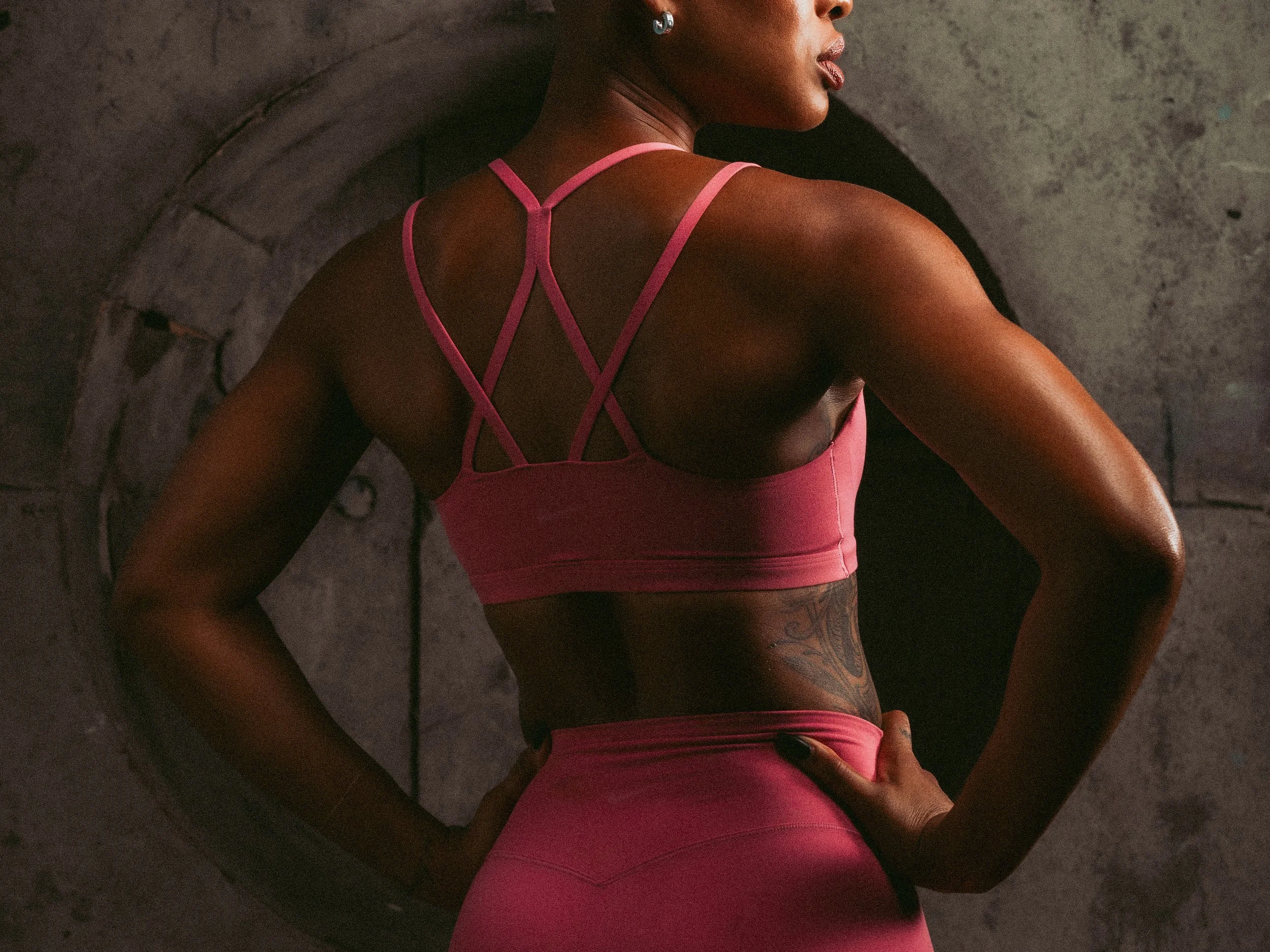 Back view of a pink strappy sports bra and leggings, activewear detail