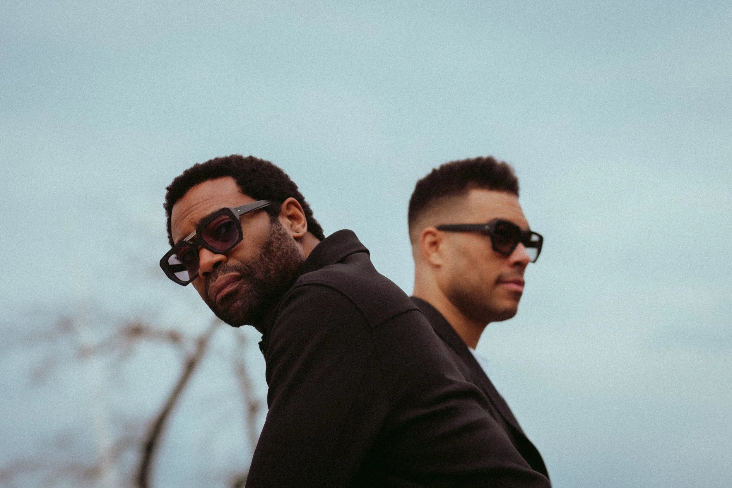 Two men in Kirk & Kirk eyewear against a pale sky