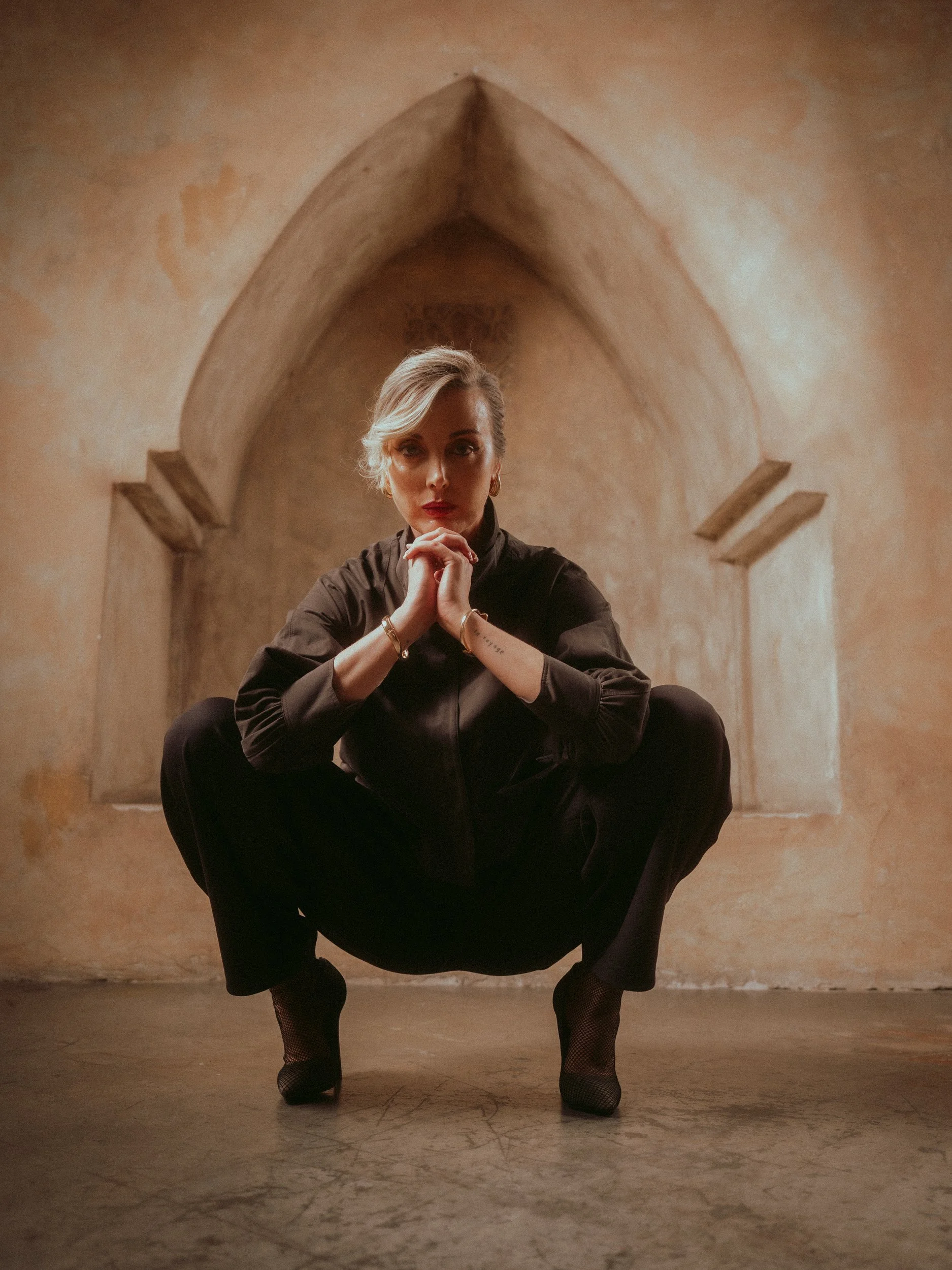 Milanka Brooks crouching in a clay arch, hands together, editorial fashion photography by Osy Ikhile, Los Angeles