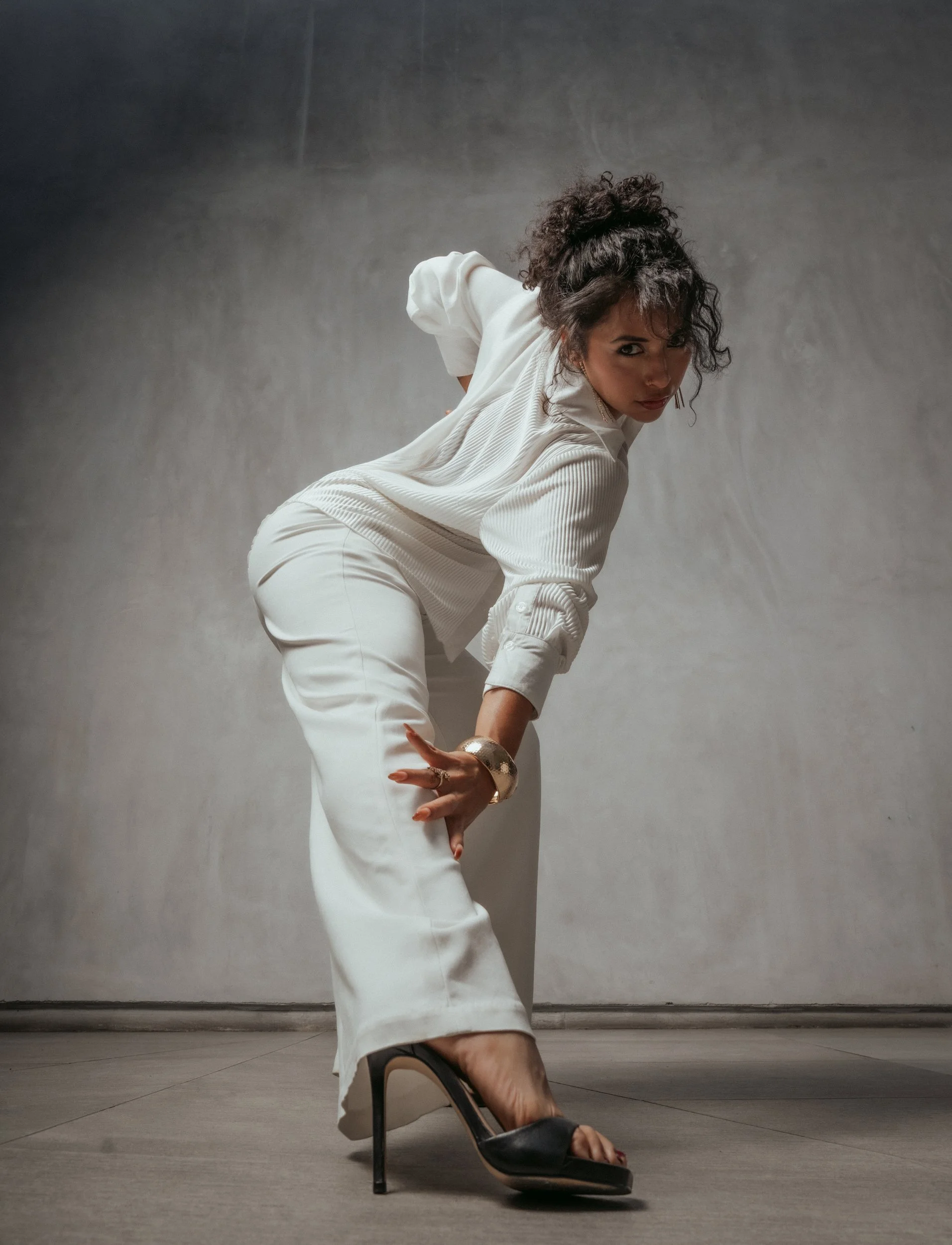 Mirna Moreno in a white suit and heels, dance portrait