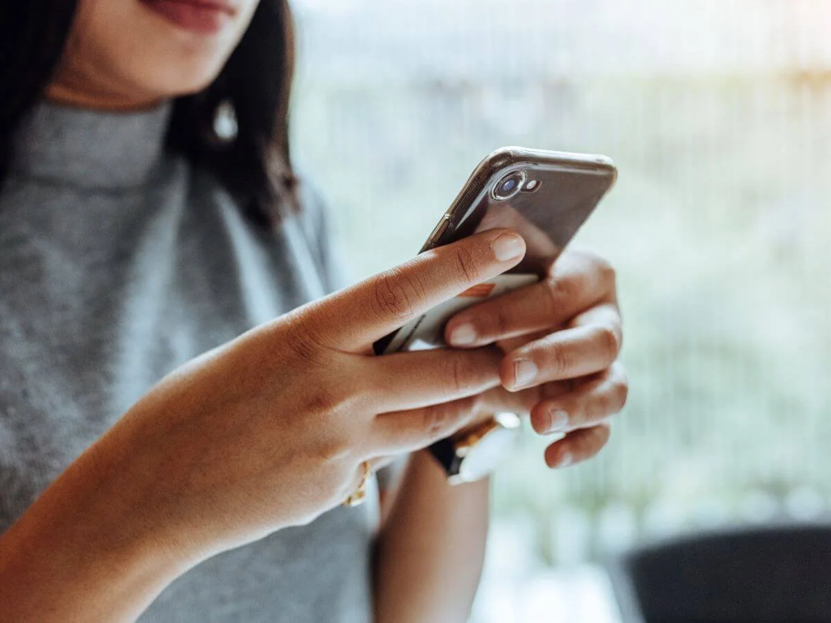 Person using a smartphone mood tracking app to monitor bipolar disorder symptoms and mood changes.