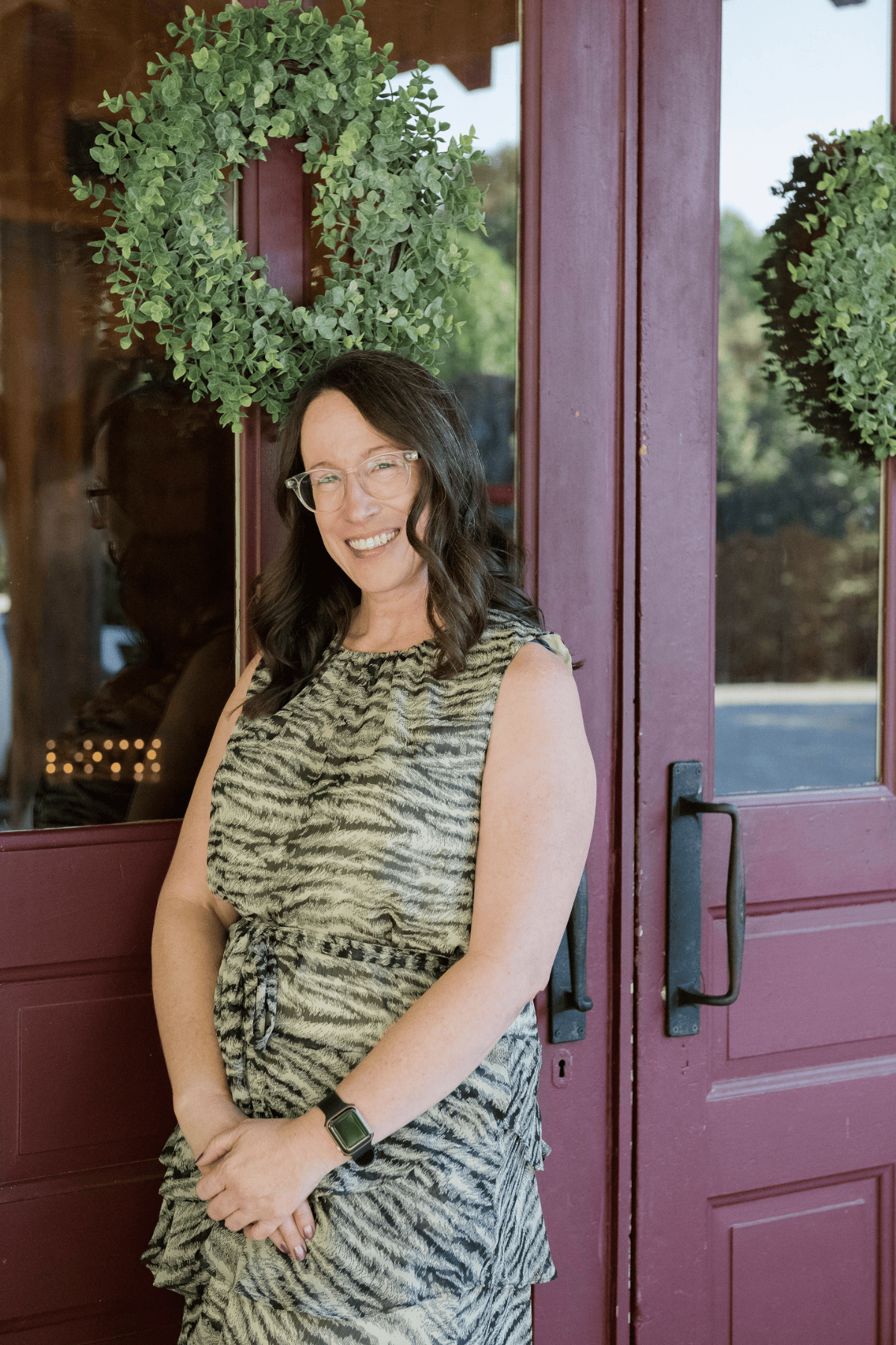 Emily Mendez, mental health writer and marketing strategist, smiling outdoors in front of purple doors.