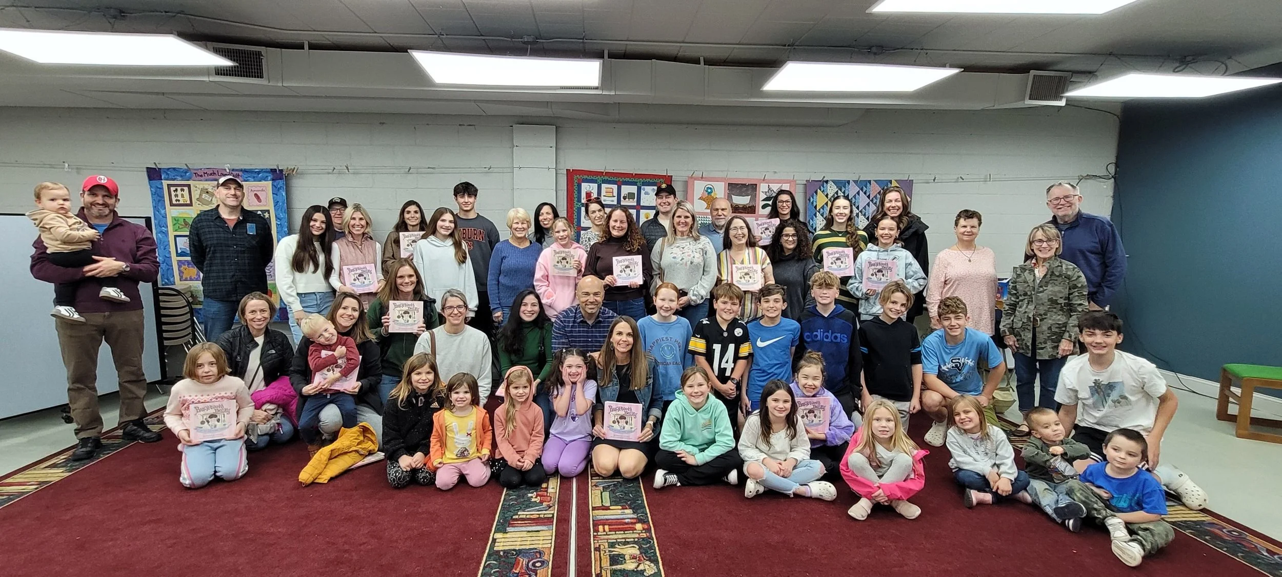 Rebecca with a group of children, parents and grandparents in a library talking about low tech and device free options. 