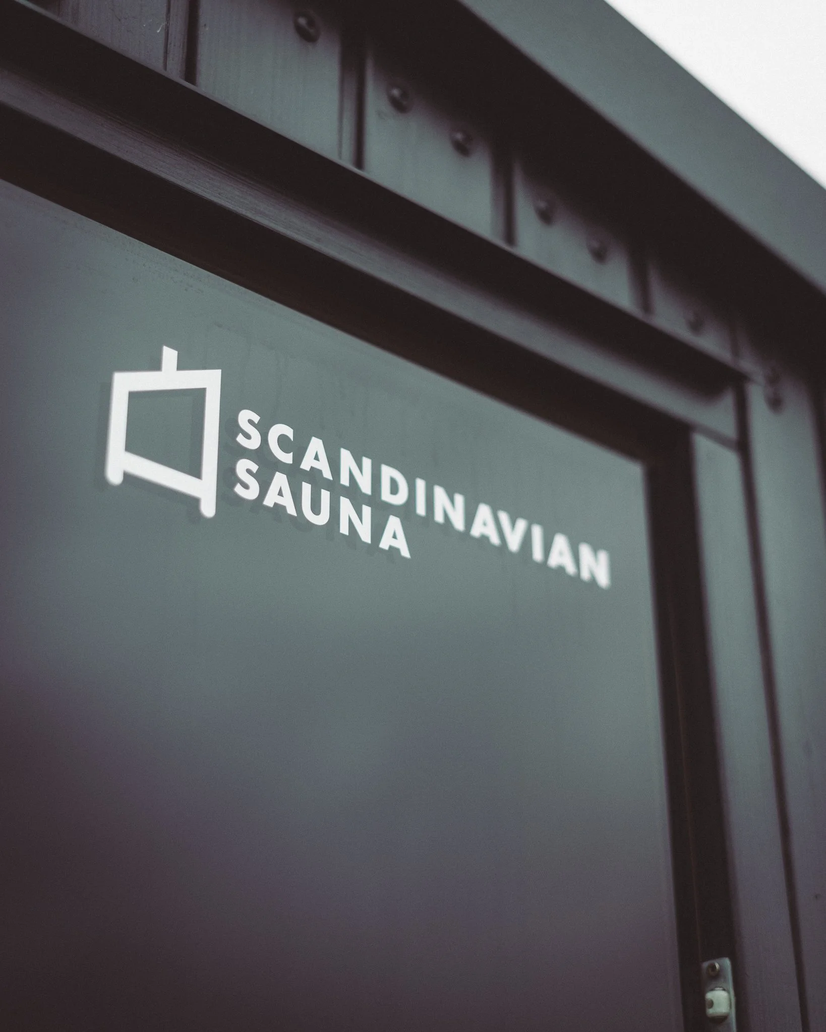 At Unfold Sauna Club Door with a sign that reads 'Scandinavian Sauna' along with a sauna icon.