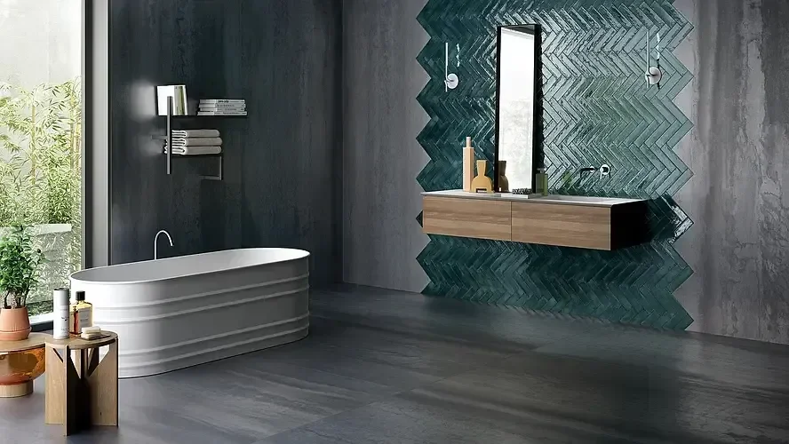 Modernes Badezimmer mit freistehender Badewanne, dunklen Wandfliesen, einem großen Spiegel und einer Holz-Waschtisch mit dekorativen Gegenständen.