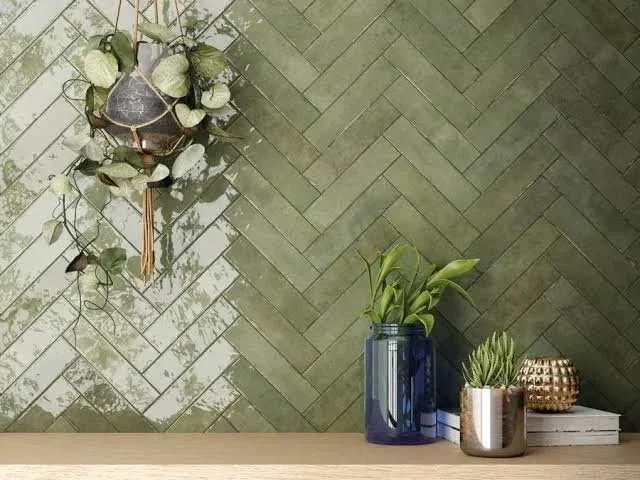 Grüner Wand mit hängenden Pflanze, Blumentopf, Kerzenhalter und Bücher auf einem Regal.
