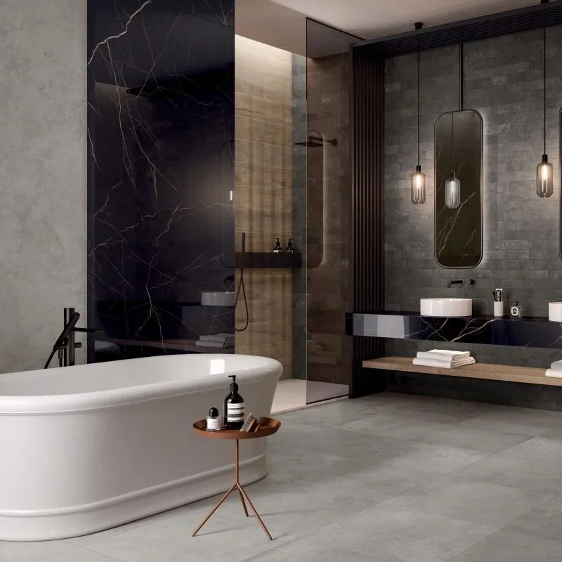 Modernes Badezimmer mit freistehender Badewanne, dunklem Wanddesign, Spiegel, Waschbecken, Handtüchern auf einer Bank und eleganten Beleuchtung.