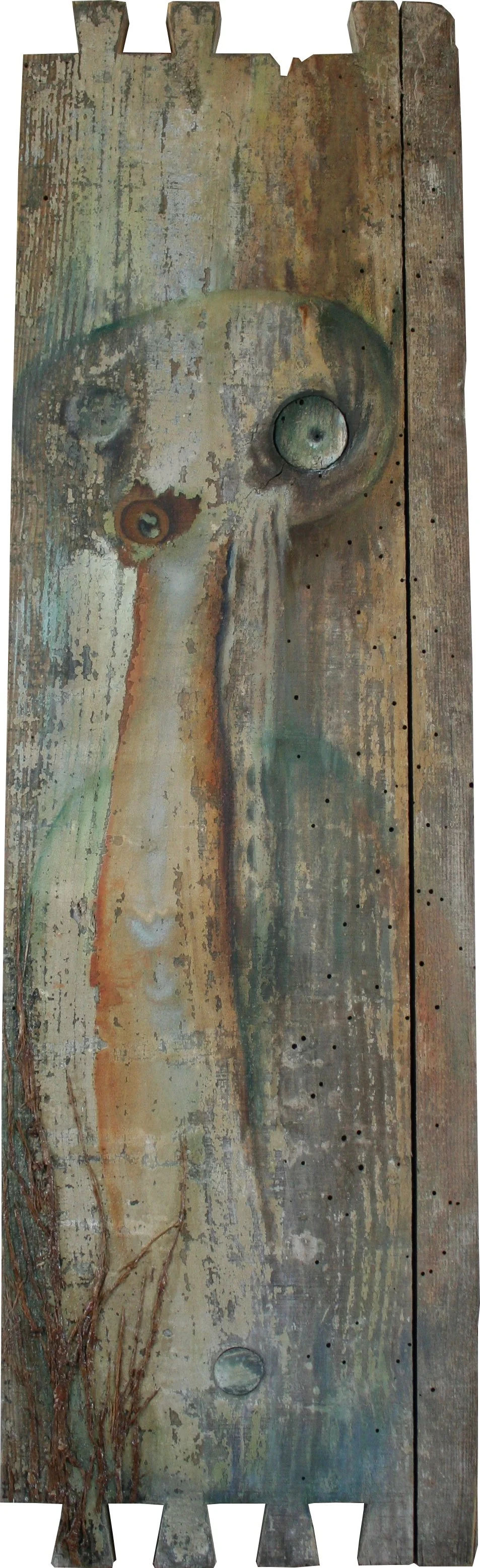 Une pièce de bois peintree pour ressembler à un visage humanoïde avec des yeux. La peinture est ancienne et déchirée, avec des zones de rouille et de décoloration.