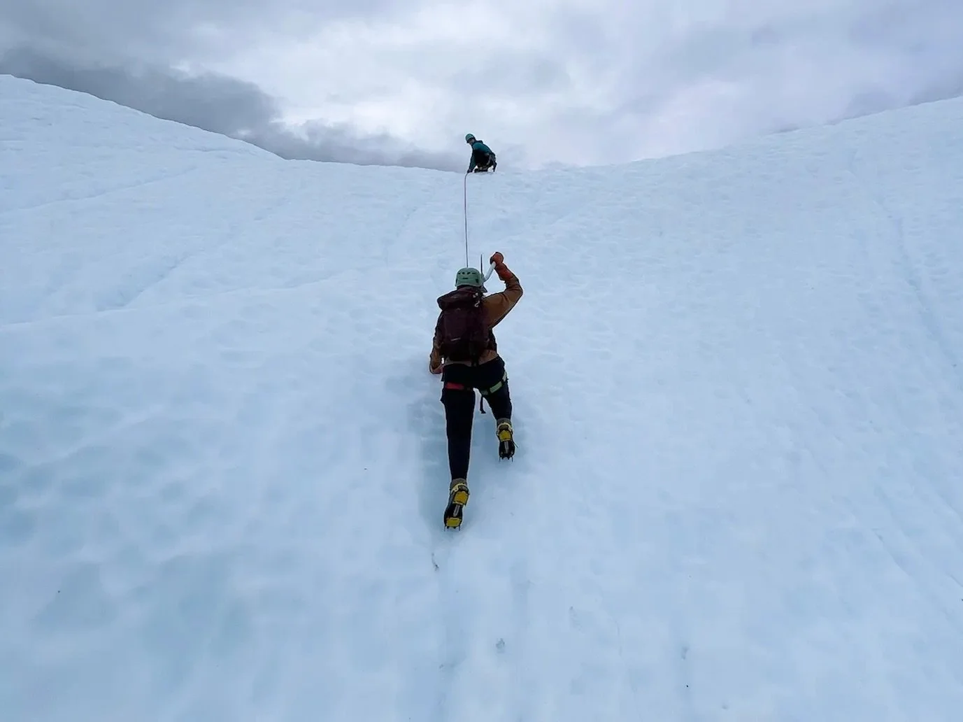 A woman climbing a glacier ice wall