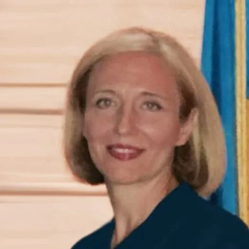 A woman with blonde hair smiling in a professional setting.