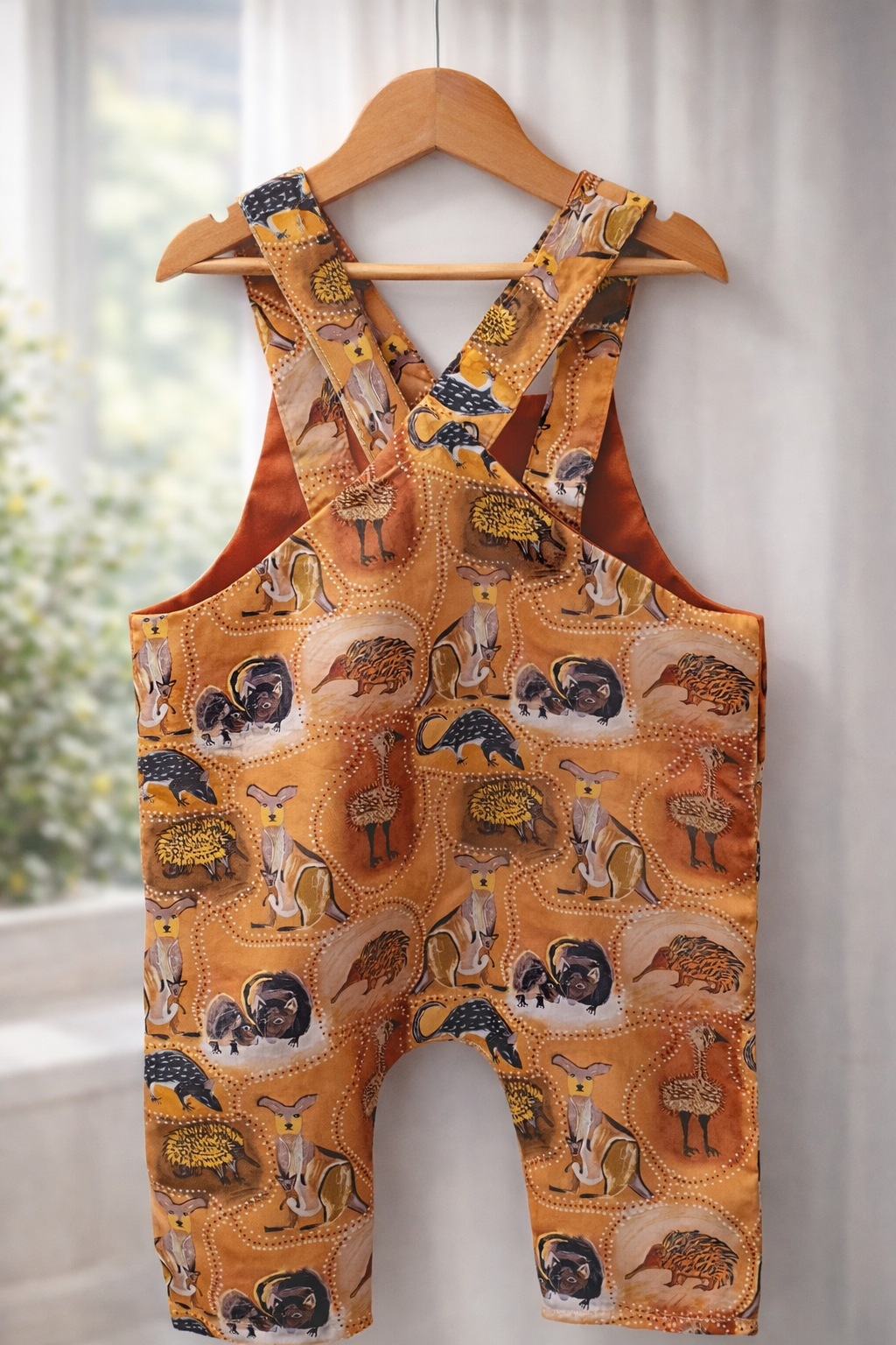 Back view of handmade Australiana baby romper featuring cross-back straps and native wildlife print 12-18 months