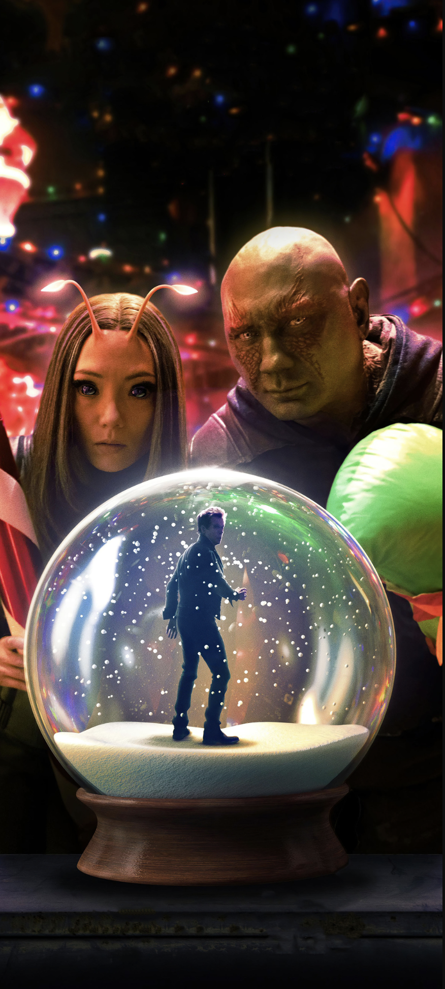 A scene from a science fiction movie showing two humans and one alien looking at a snow globe with a miniature man inside, surrounded by colorful lights and blurred background.
