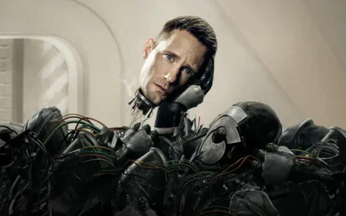 A humanoid robot with a human's face, looking confused or concerned, surrounded by mechanical parts and wires.