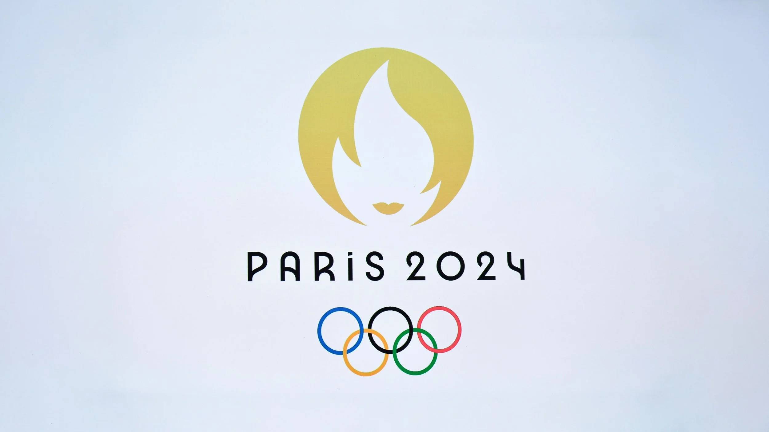 Logo for Paris 2024 Olympics featuring a stylized woman's face with short hair, the text 'PARIS 2024', and the Olympic rings.