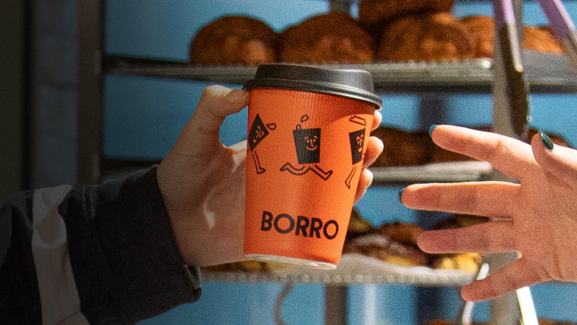 Small-business  owner handing a  BORRO cup to  customer.