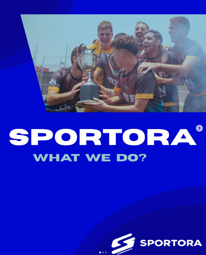 A group of young male athletes in sports uniforms celebrating and holding a trophy on a sports field.