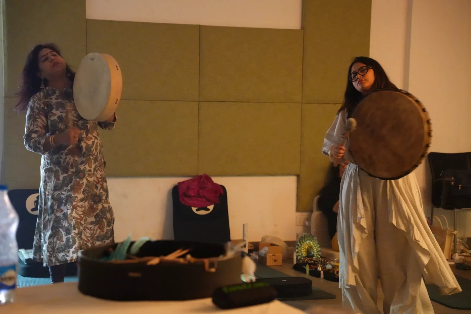 Two participants practising frame-drum rhythms during a supervised experiential shamanism exercise at Soul Consciousness Lab.