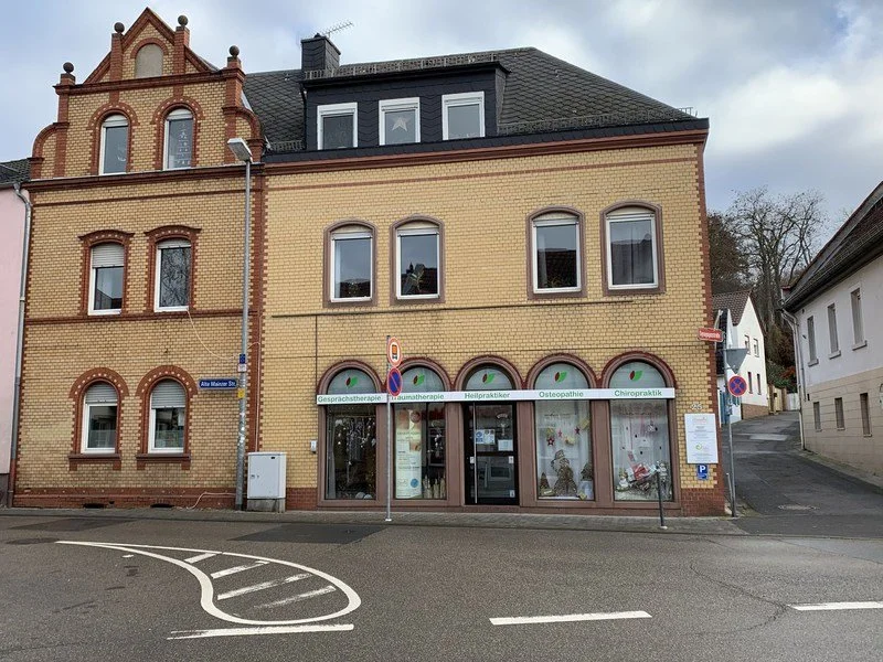 Außenansicht der Sanadios Ganzheitliche Naturheilpraxis in Mainz-Hechtsheim mit dem gesamten Praxisgebäude, Eingangsbereich und Standort der Praxis für Gesprächstherapie, Traumatherapie, Osteopathie und Chiropraktik.
