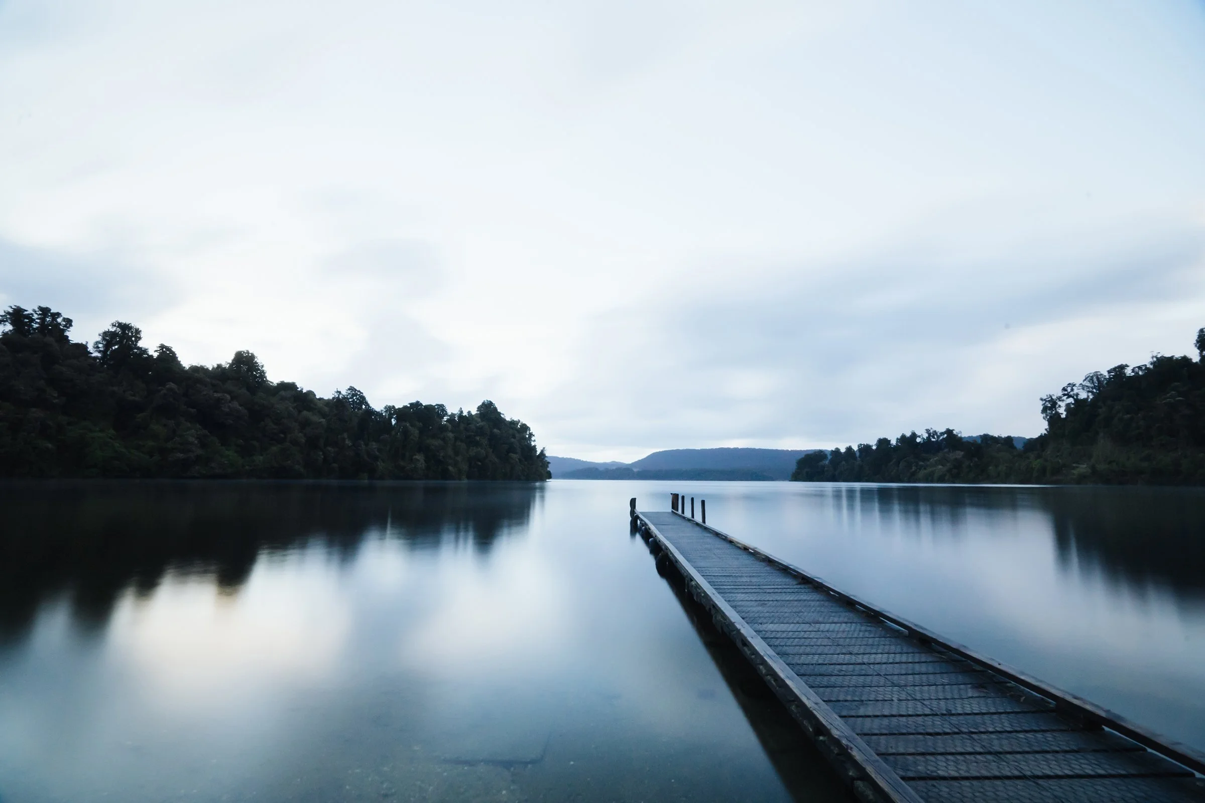 Steg auf einem ruhigen See mit weitem Horizont als Sinnbild für neue Perspektiven, persönliche Entwicklung und vertrauensvolle Begleitung im Online-Format.