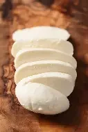 Sliced white cheese on a wooden surface