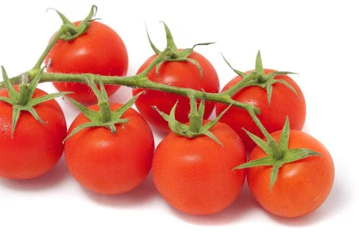 A bunch of ripe cherry tomatoes on the vine.