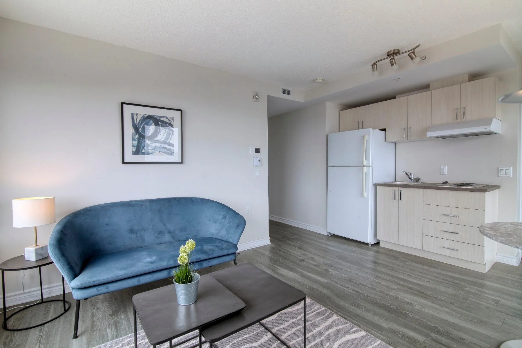 Espace de vie ouvert et cuisine dans un appartement témoin de la Résidence Le Parc
