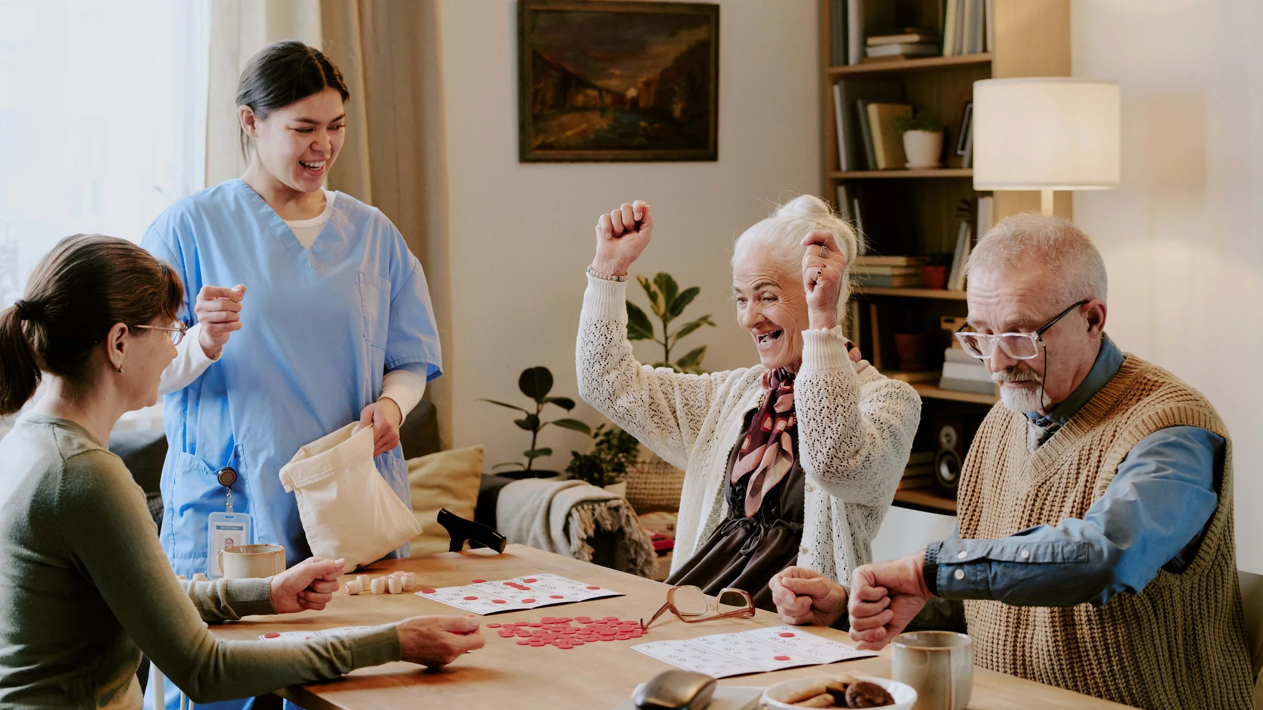 Seniors playing bingo together with a caregiver in a retirement community.