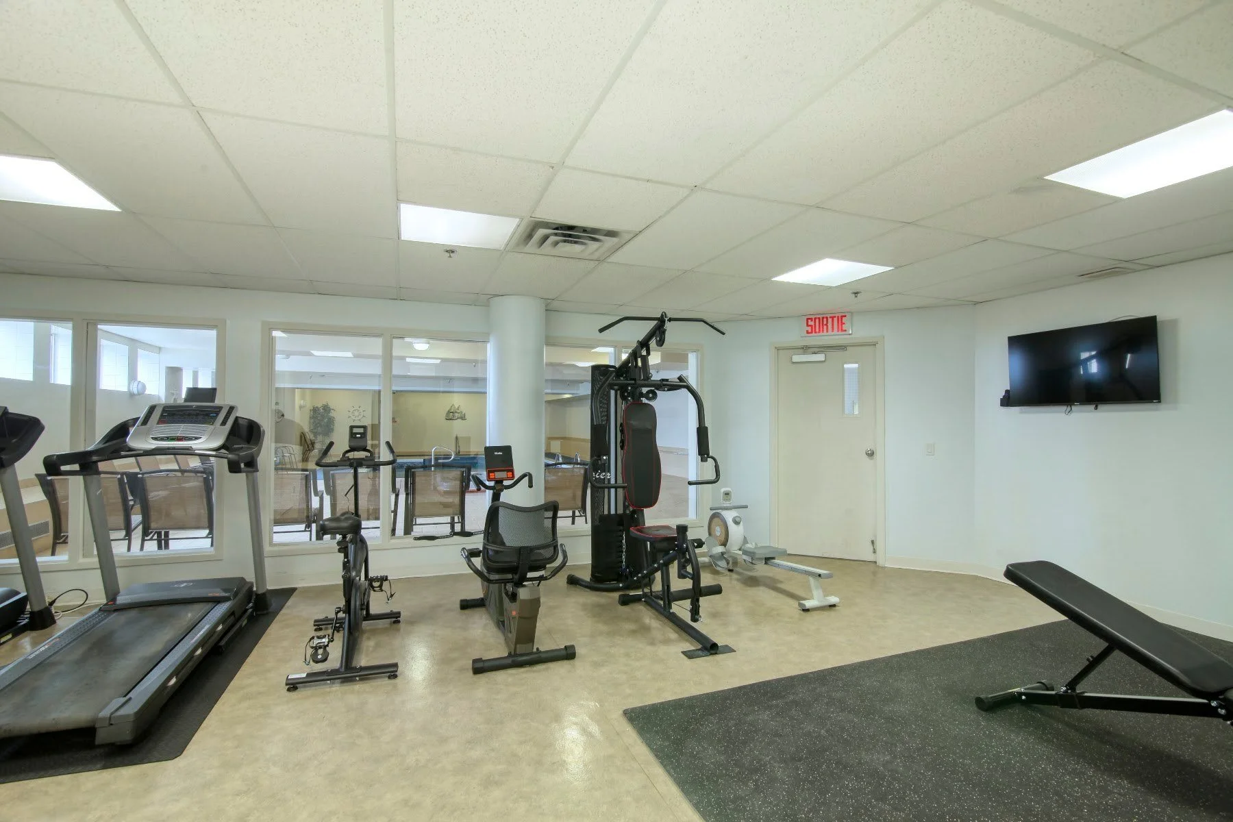 Centre de conditionnement physique avec tapis roulants et appareils de musculation à la Résidence Le Parc