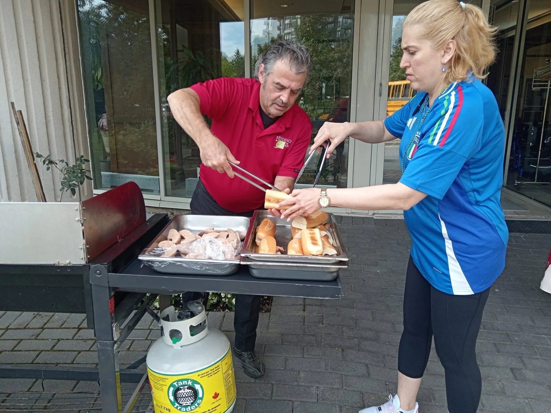 Le personnel grille au barbecue d'été de la Résidence Le Parc