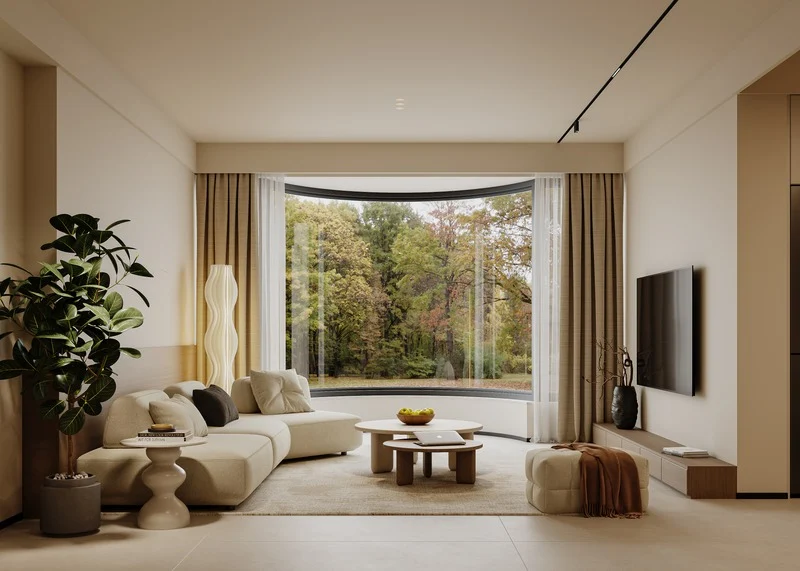 Modern living room with a large window overlooking trees, beige sofa, coffee table, large plant, wall-mounted TV, and minimal decor.