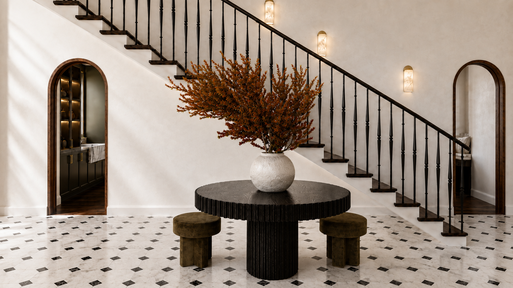 Luxury contemporary foyer in Potomac, Maryland, featuring a sculptural black round table, arched doorways, curved staircase with black metal railing, patterned stone flooring, and warm neutral finishes.
