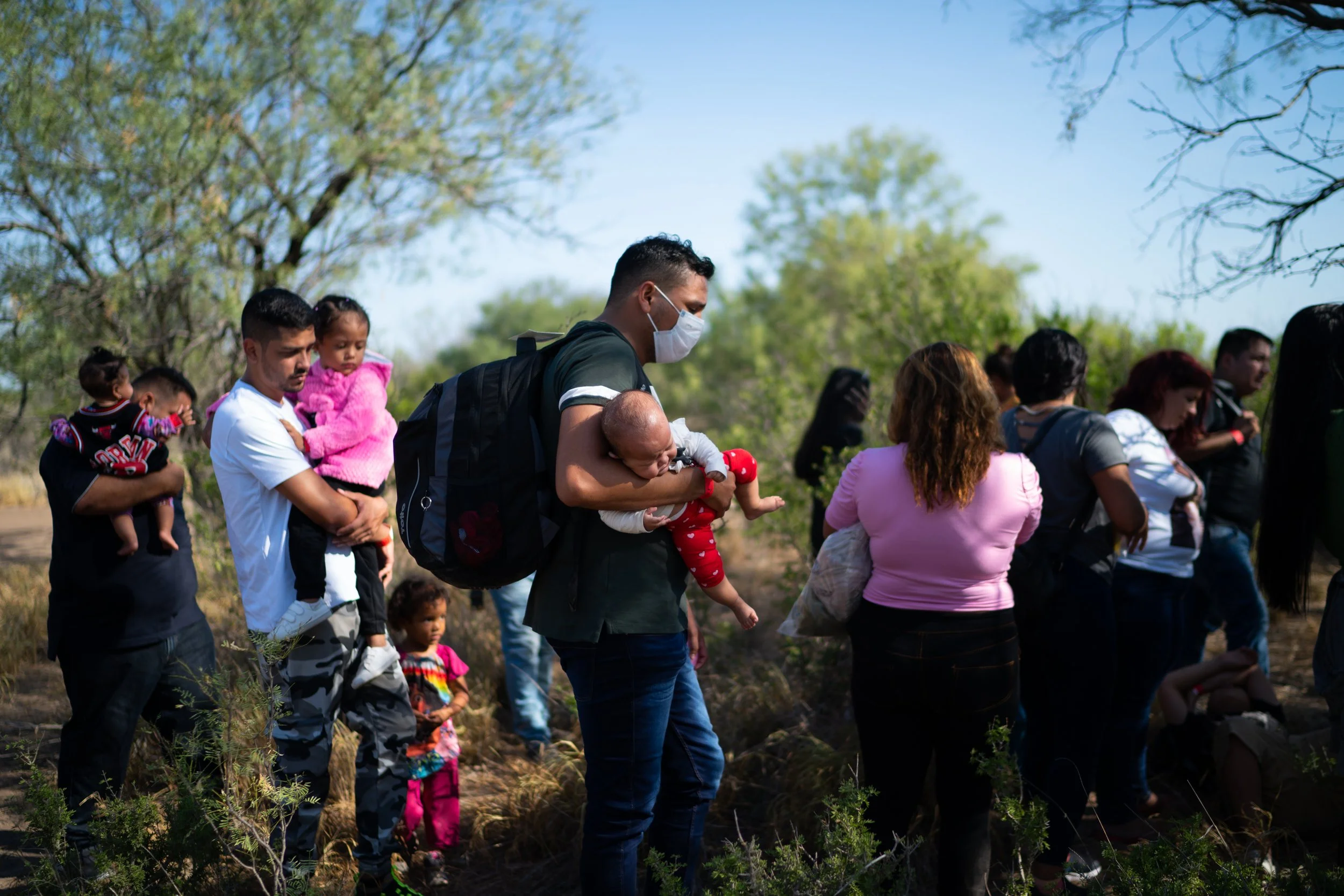 A group of 220 migrants, including families with infants, is taken into custody after crossing the Rio Grande in Eagle Pass, Texas, Aug. 12, 2022. Texas Gov. Greg Abbott offered migrants free bus transportation to Washington to protest the Biden admi