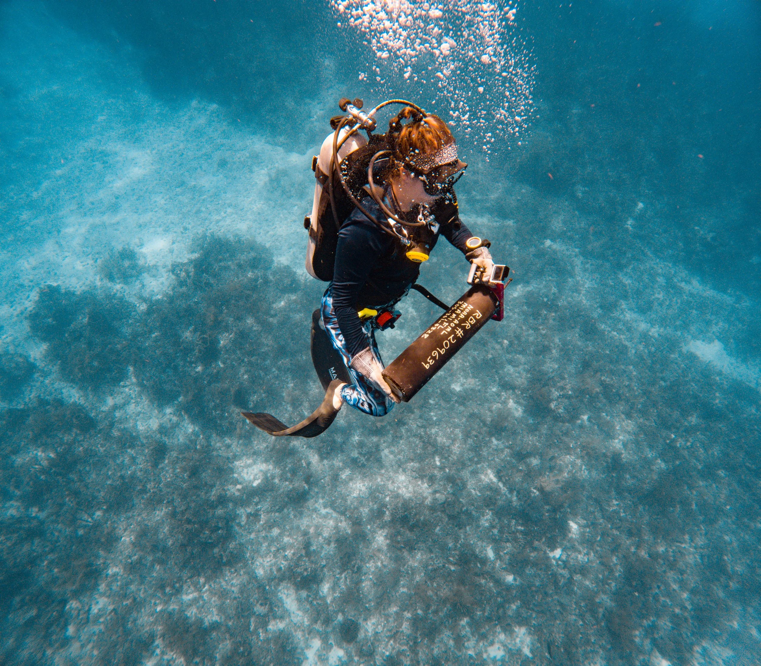 Leah Chomiak carries a scientific instrument retrieved from the seafloor that had been collecting data on the Florida Current.