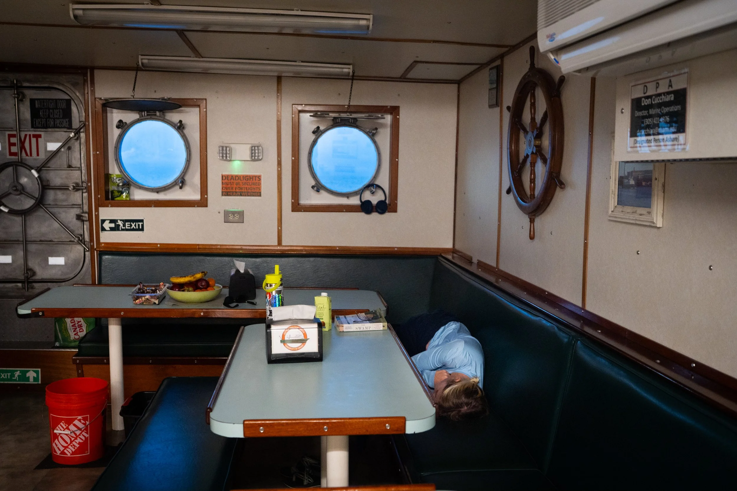 Tyler Christian takes a brief nap in the galley as the vessel travels back to Miami following days of fieldwork.