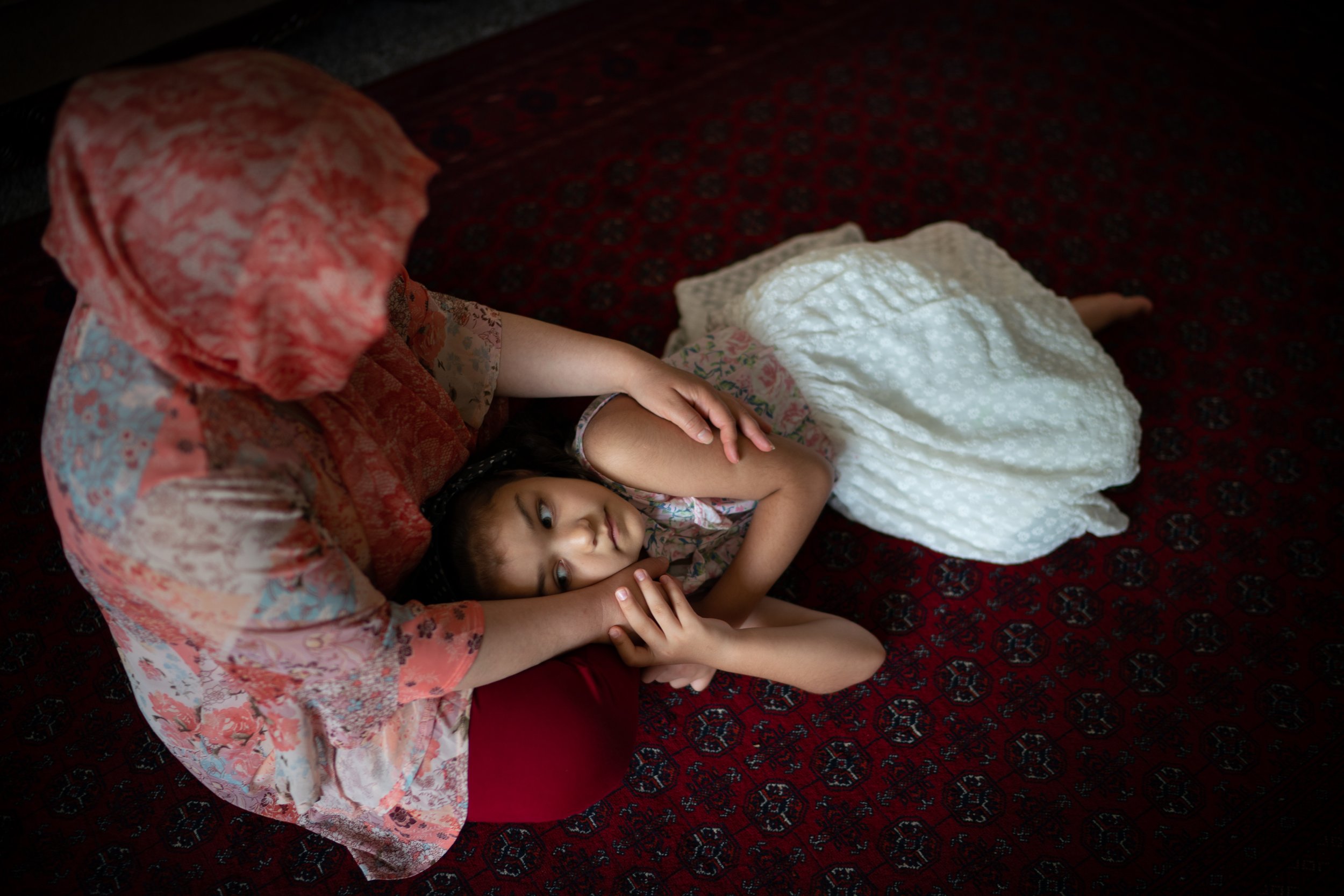 Nasrin Noor, 39, sits with her daughter Fatima, 8, at their home in Alexandria, Va., July 7, 2021. The family recently arrived from Afghanistan through the Special Immigrant Visa program, which helps Afghans who worked alongside the U.S. military res
