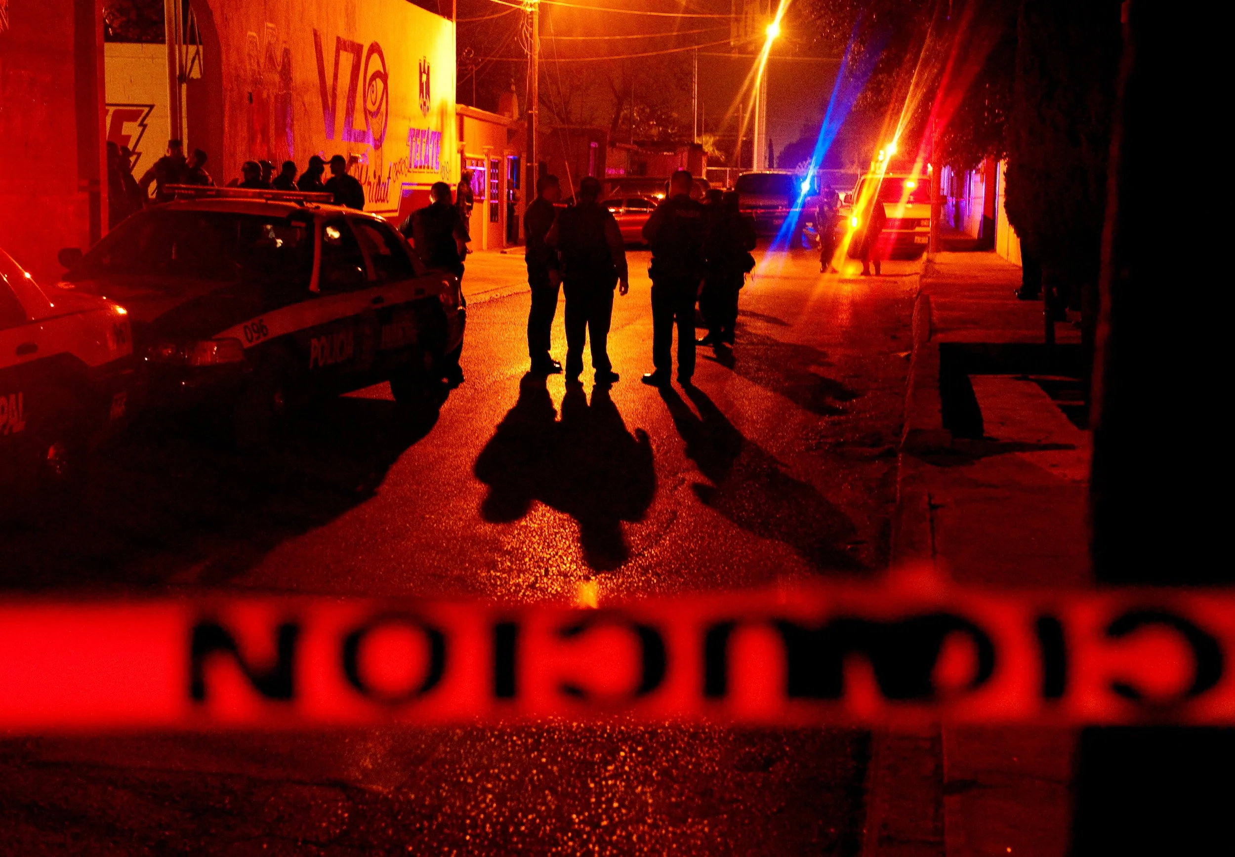 Mexican soldiers and police stand outside a bar in Ciudad Juarez, Mexico, April 19, 2009, shortly after its owner was killed. The military had taken control of the city in an effort to curb escalating drug cartel violence.