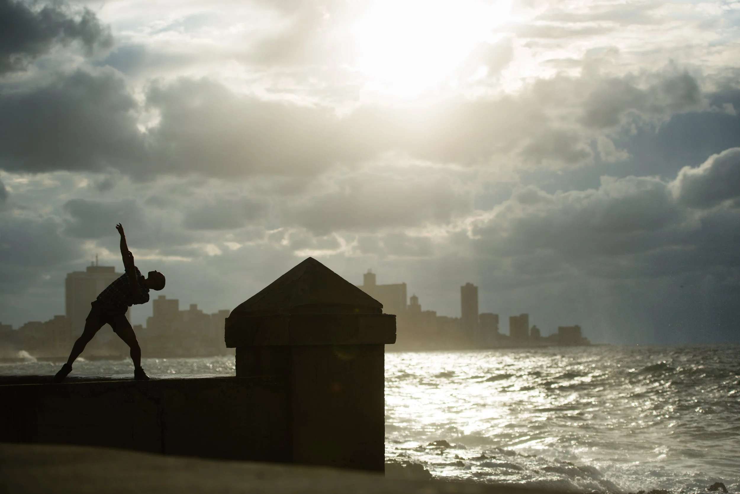 Cuban contemporary dancer, Henry Labrada, 23, is silhouetted against the Havana skyline as he dances on the sea wall of The Malecon on March 28, 2015.