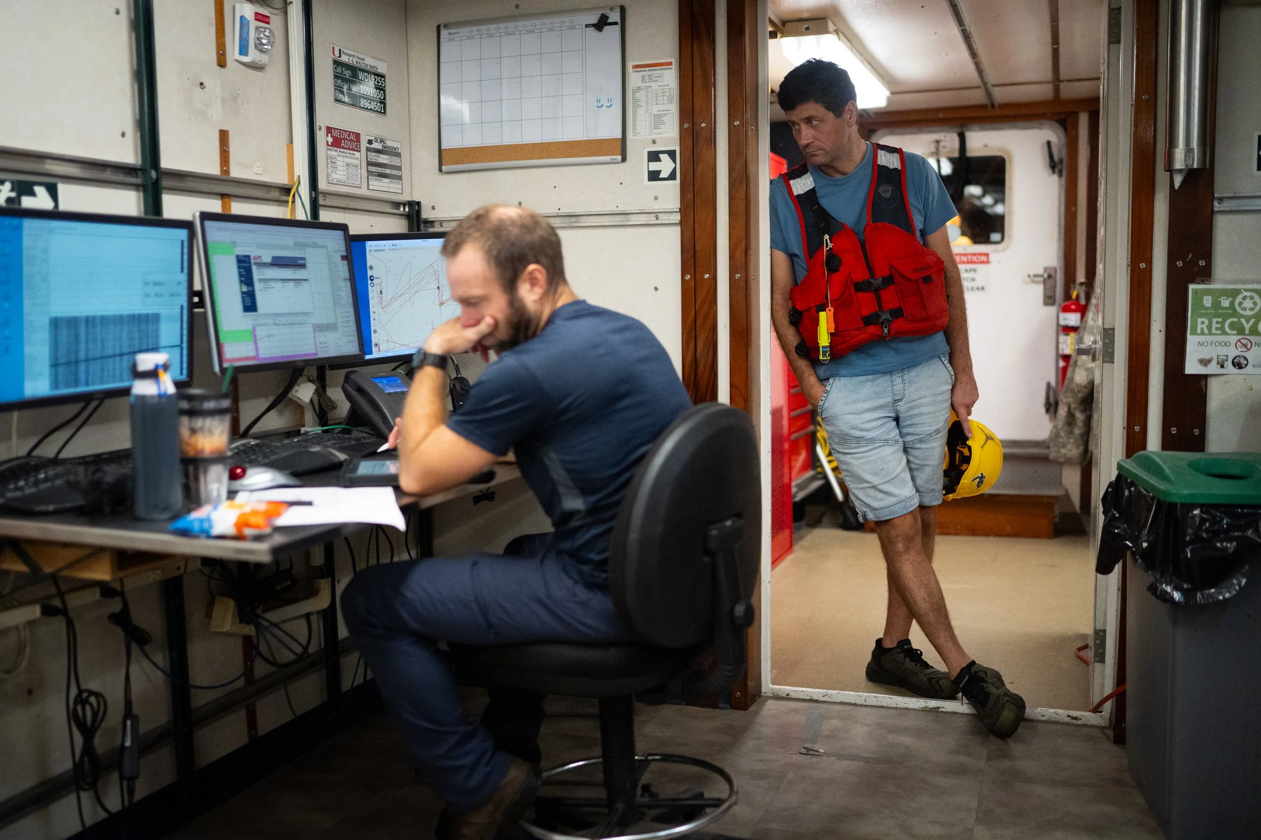 Around 4 a.m., Denis Volkov, right, leans against a wall as Jay Hooper, 42, works during overnight data collection.