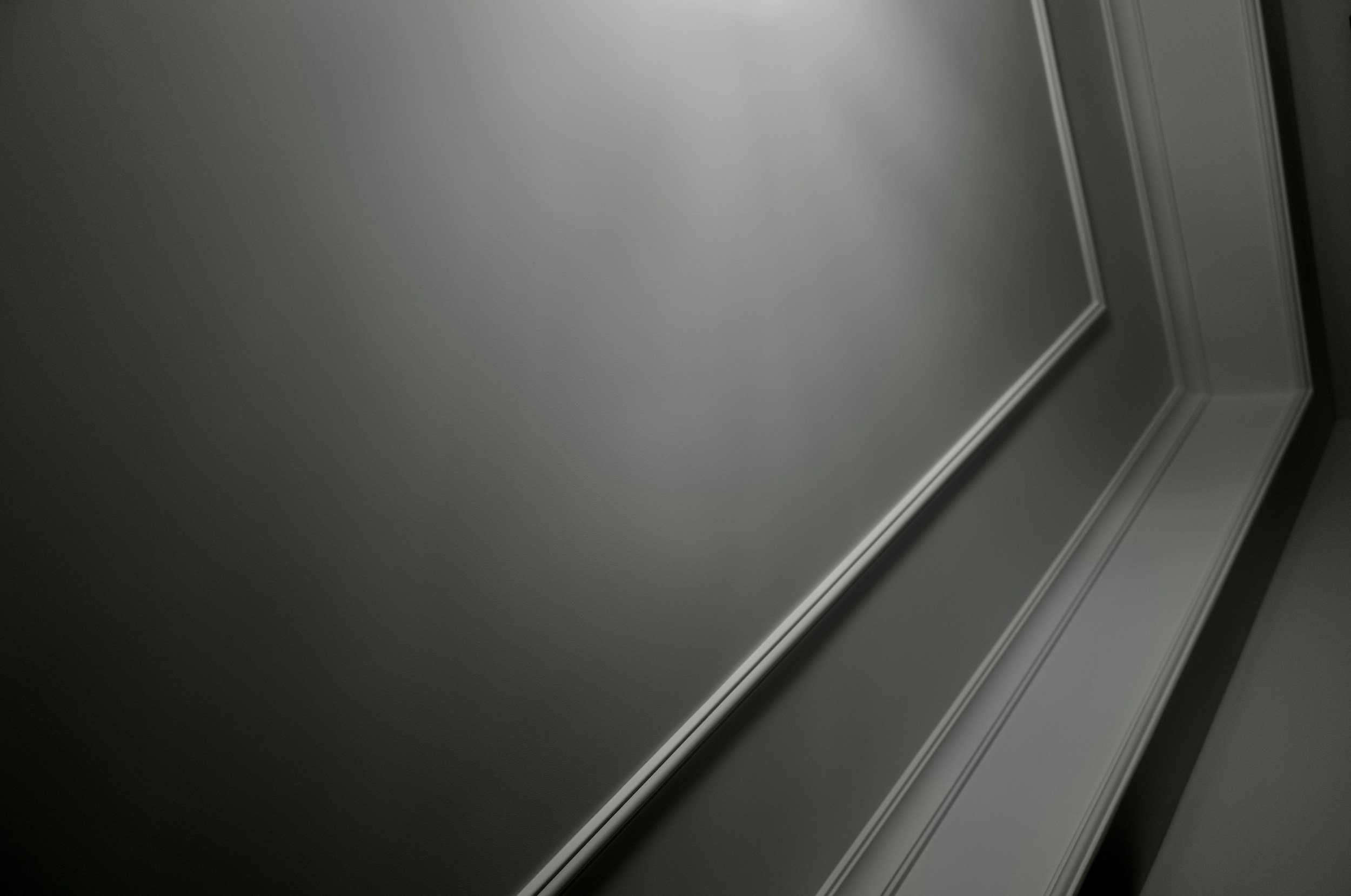 Close-up of a door frame with detailed molding, painted in light gray or off-white color.