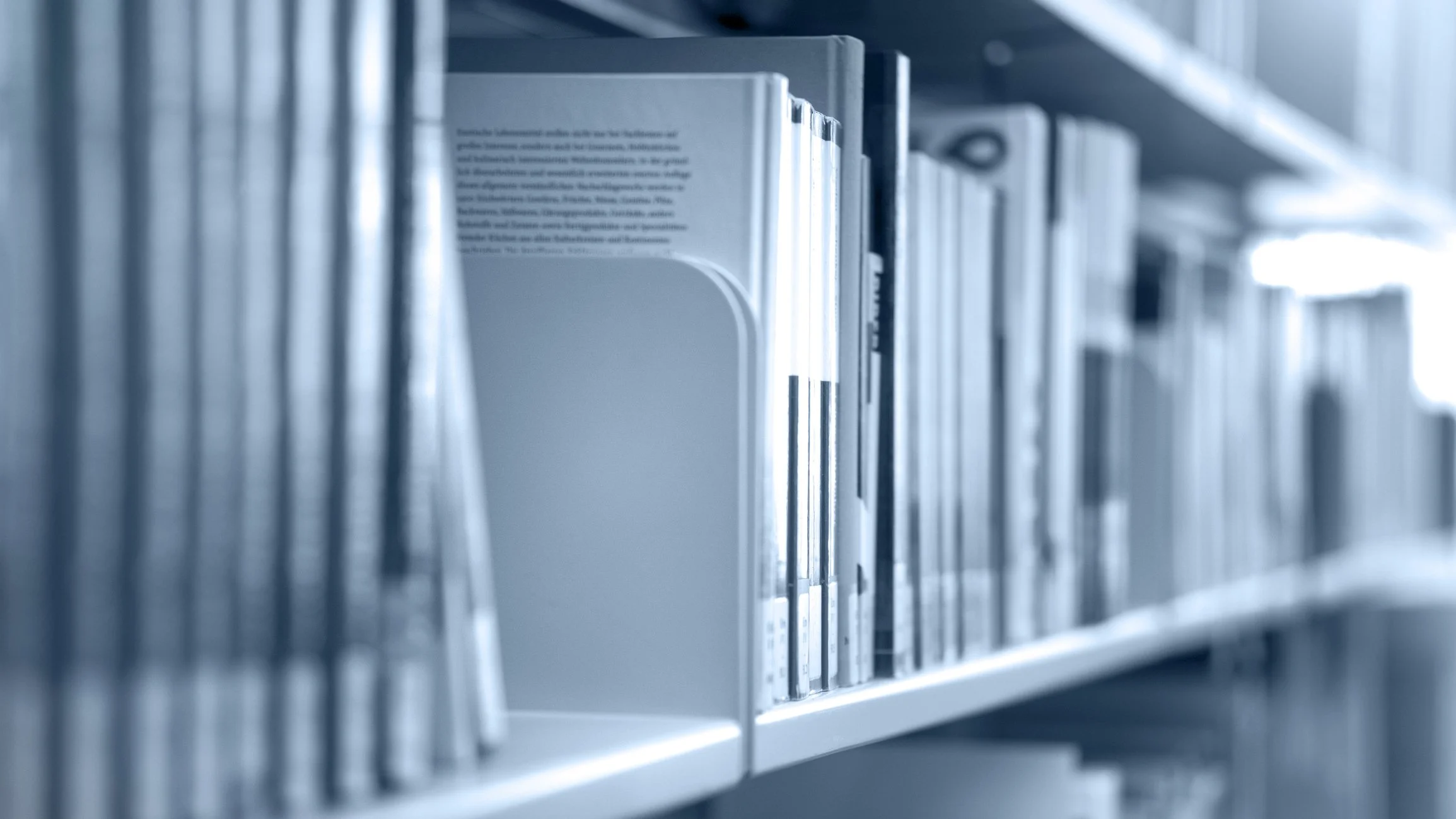 Books on a library shelf with a focus on the middle section.