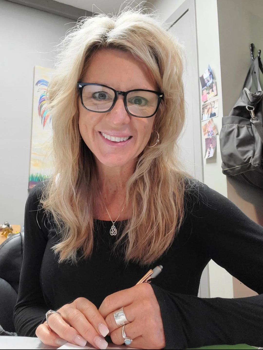 Shari writing information down and smiling at the camera.