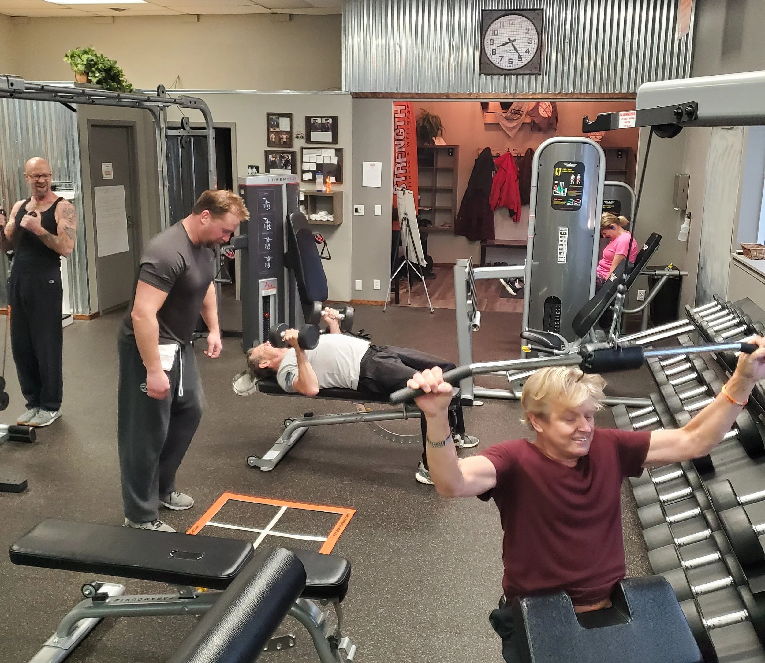 Group of people working out and using gym equipment