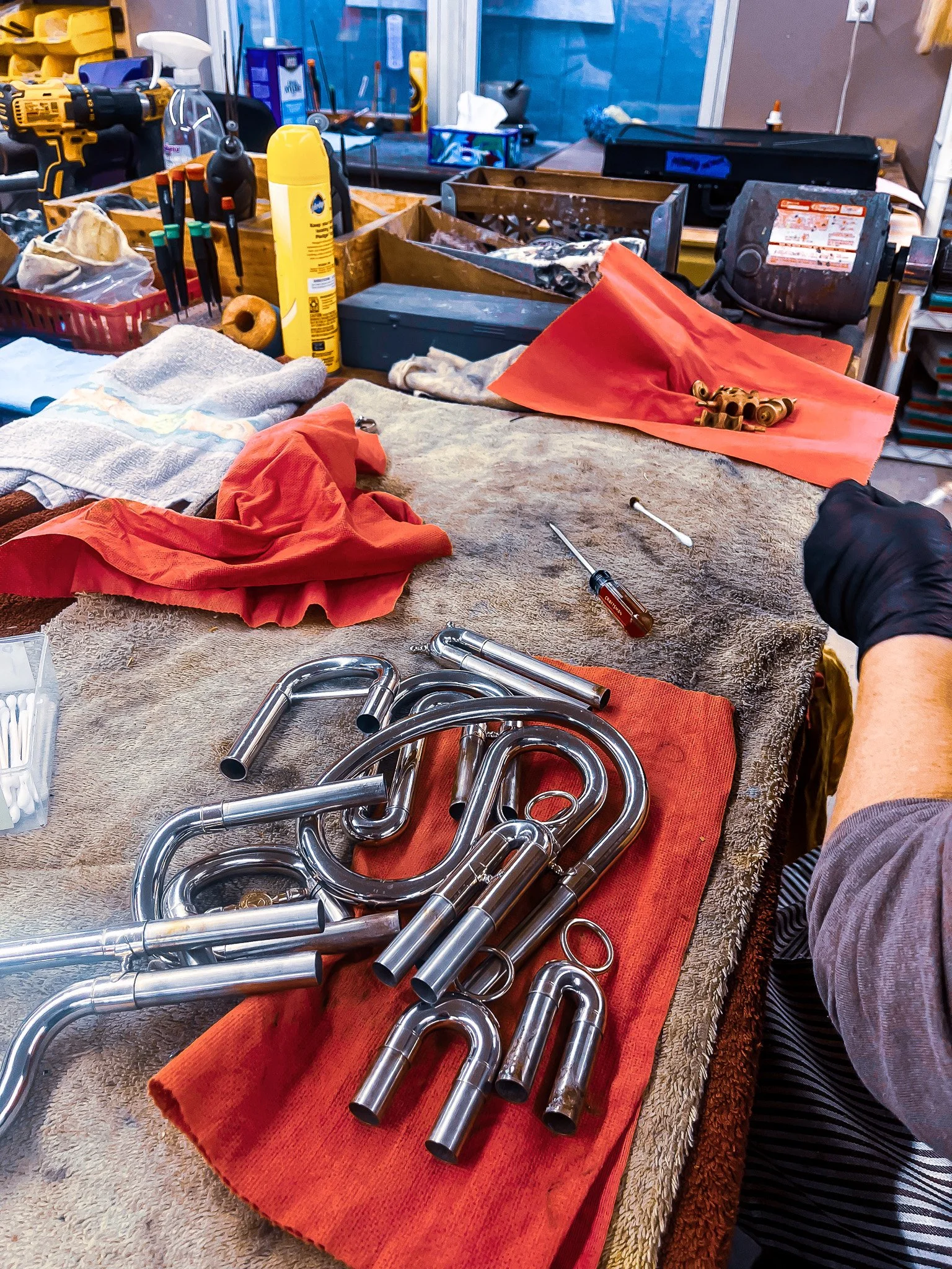 Tools and metal pipes on a workbench in a workshop.
