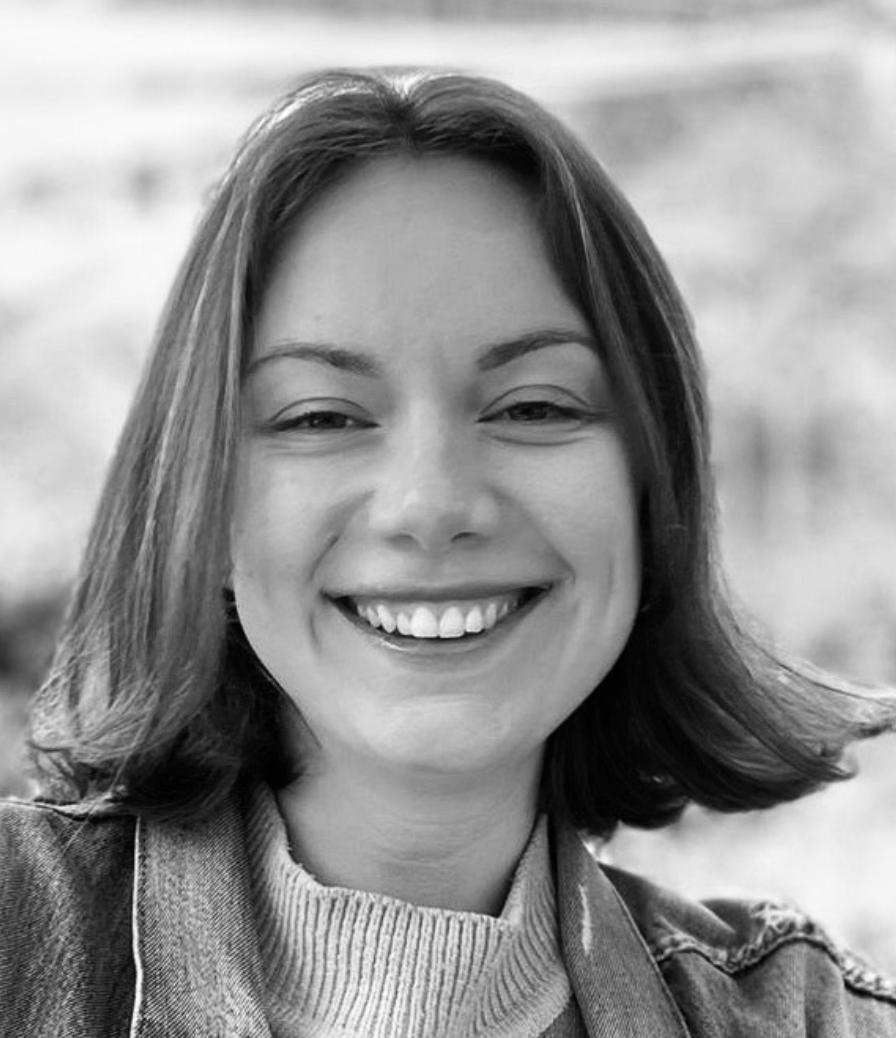 Portrait d'une femme souriante avec des cheveux mi-longs et un pull à rayures, en noir et blanc.