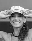 Femme souriante portand un chapeau, saluant de la main