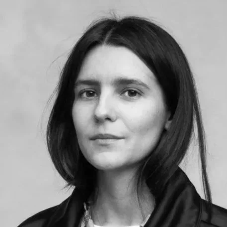 Portrait en noir et blanc d'une femme avec des cheveux mi-longs, portant une veste en cuir.