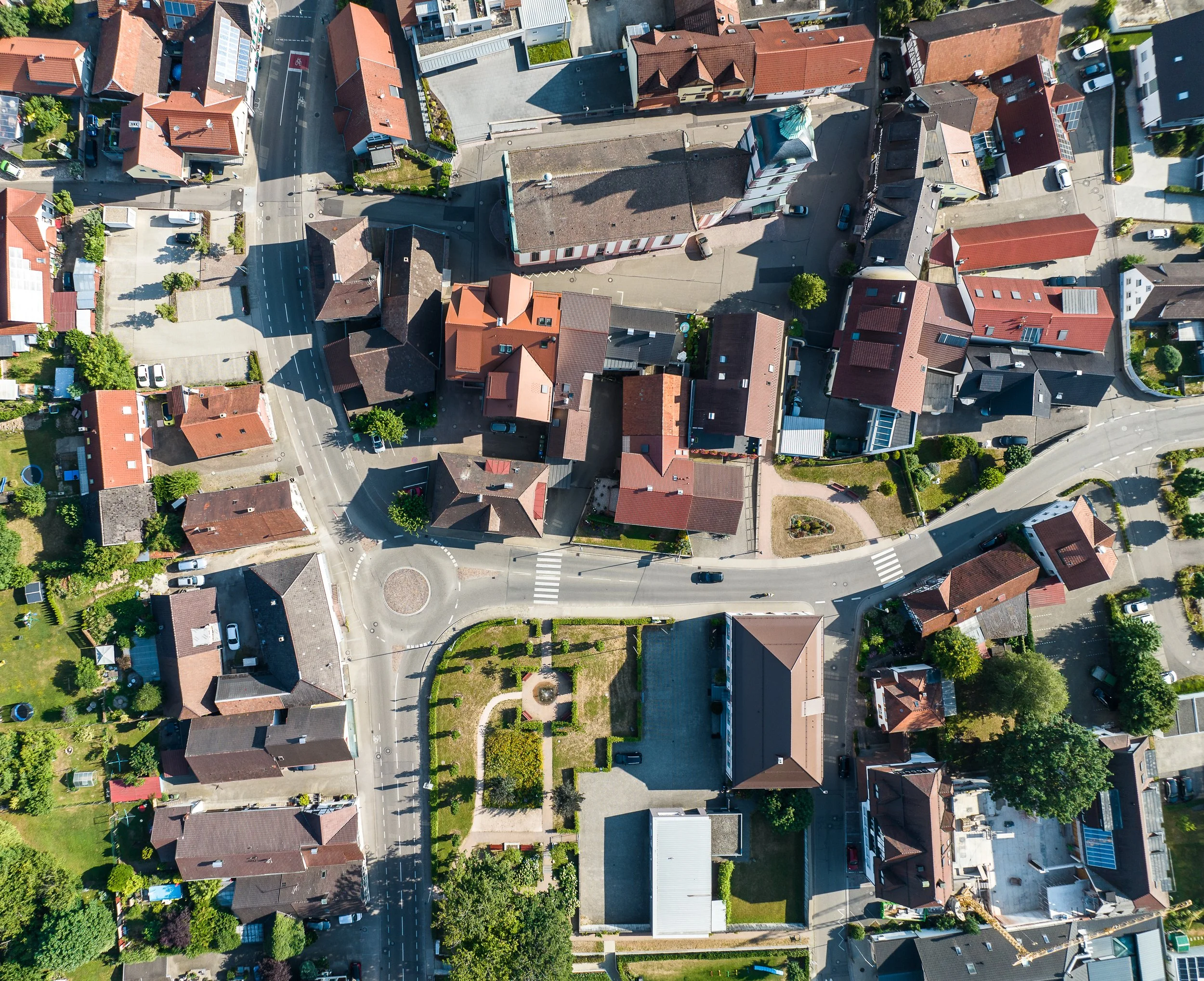 Vogelperspektive auf eine dicht besiedelte Wohngegend mit Straßen, Häusern, Gärten und Bäumen