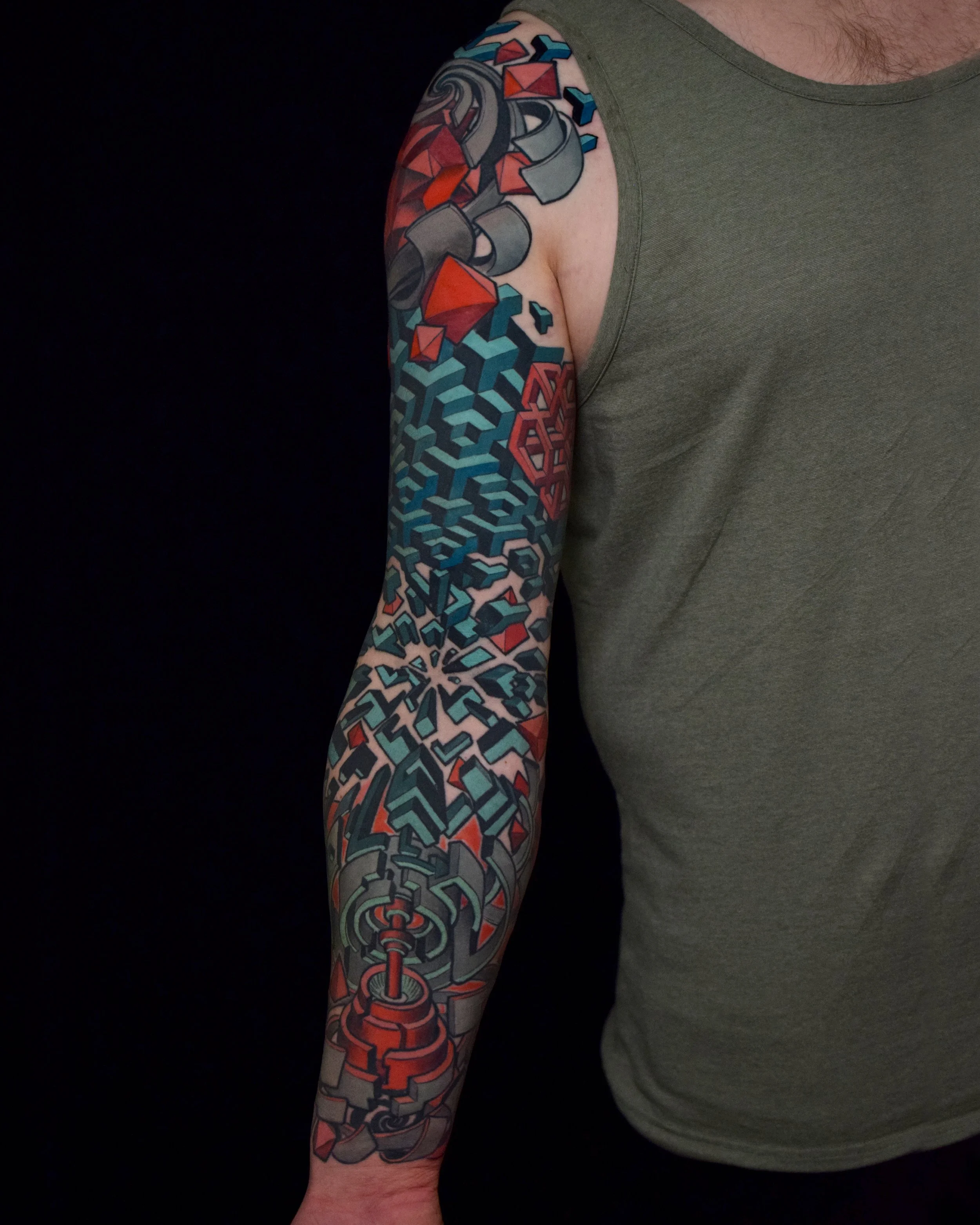A person's upper arm and shoulder with a colorful geometric tattoo design.