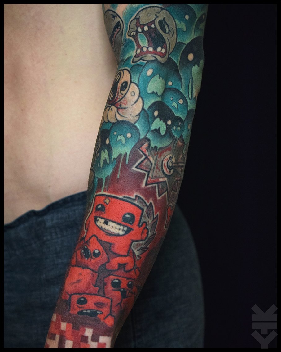 Colorful tattoo sleeve featuring cartoonish characters and abstract elements, including a smiling red character with braces, stacked smaller red figures, and various abstract shapes and faces.